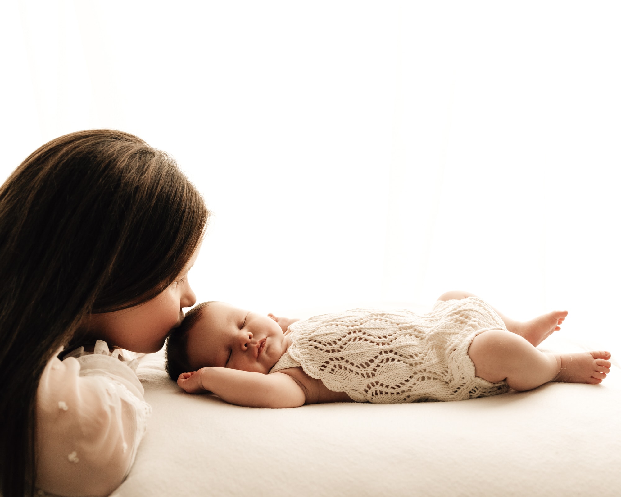 a sister with her newborn baby during a leeds newborn photographer photoshoot