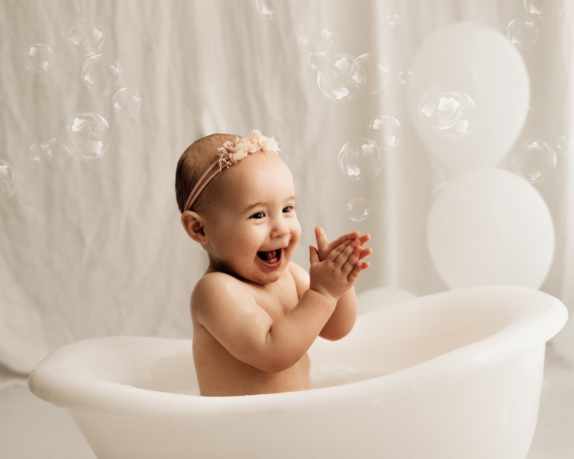 baby smiling in a bath tub during a bradford cake smash photographer photoshoot