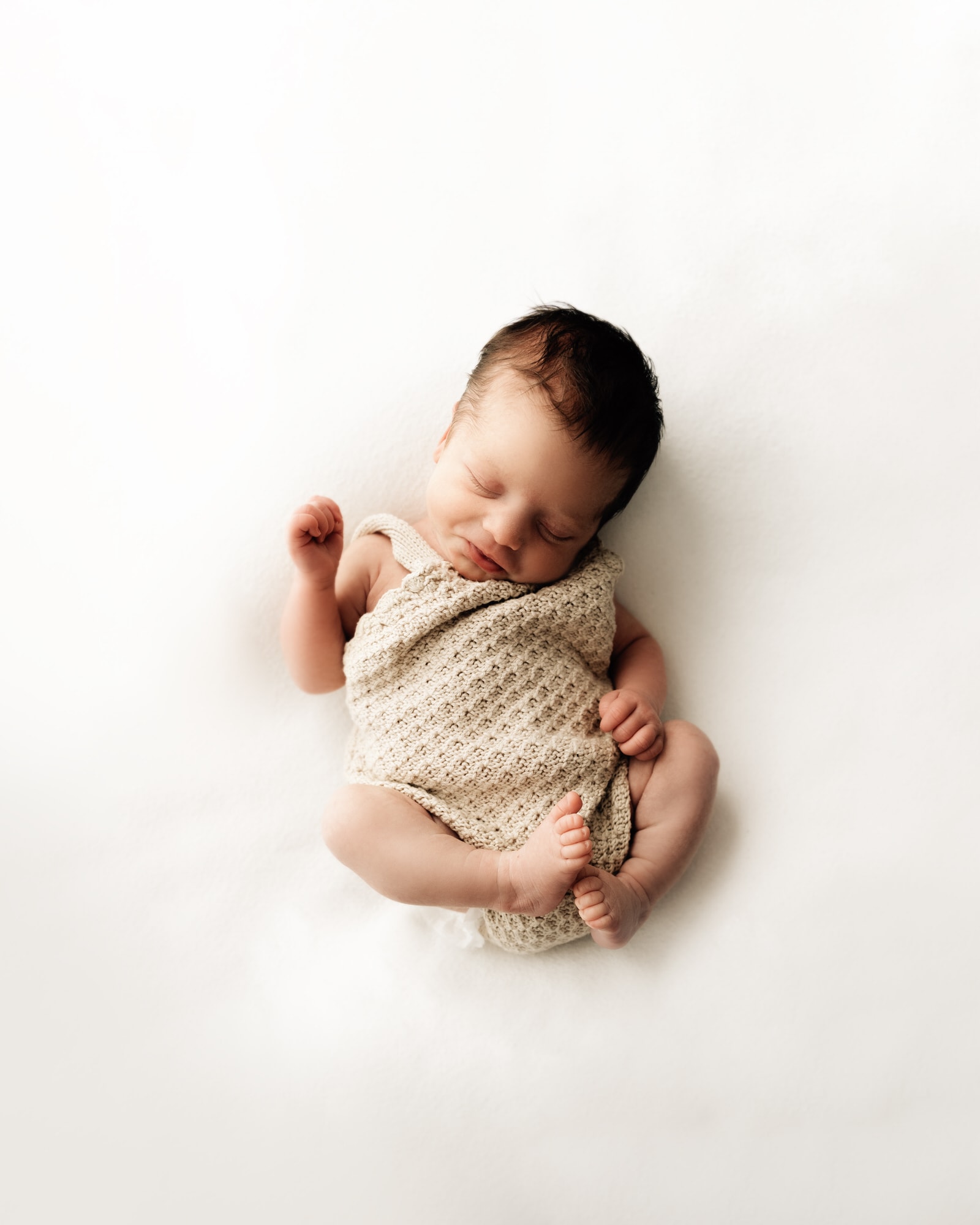 newborn baby curled up on bradford photography session