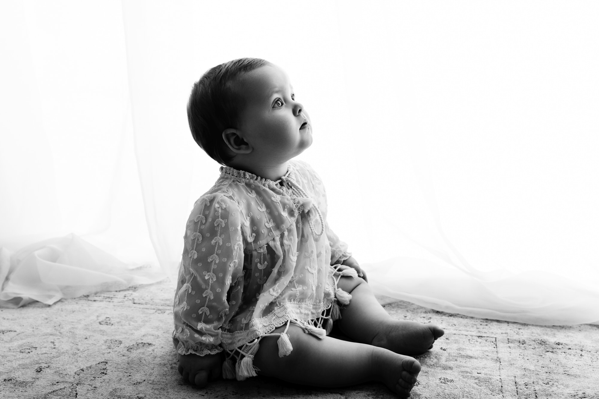 black and white image of a baby looking up during a bradford baby photographer photoshoot