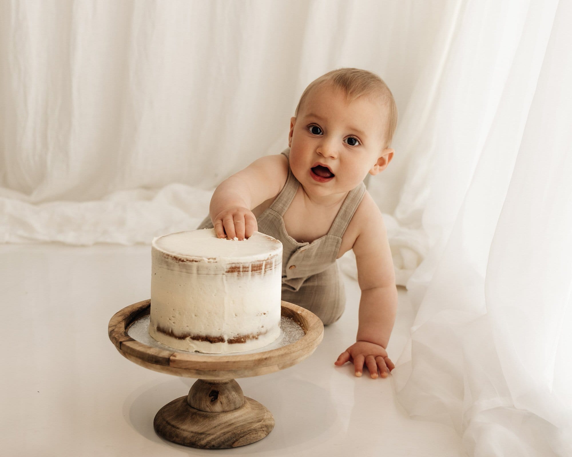baby grabbing cake during a bradford cake smash photoshoot