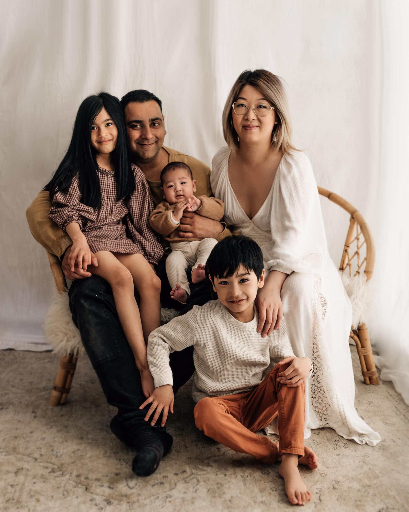 family sat smiling during their studio photoshoot in bradford