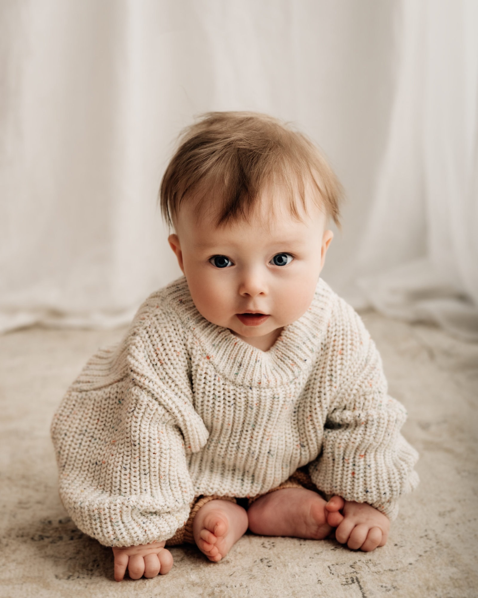 baby sat up looking at the camera in a bradford baby photography studio