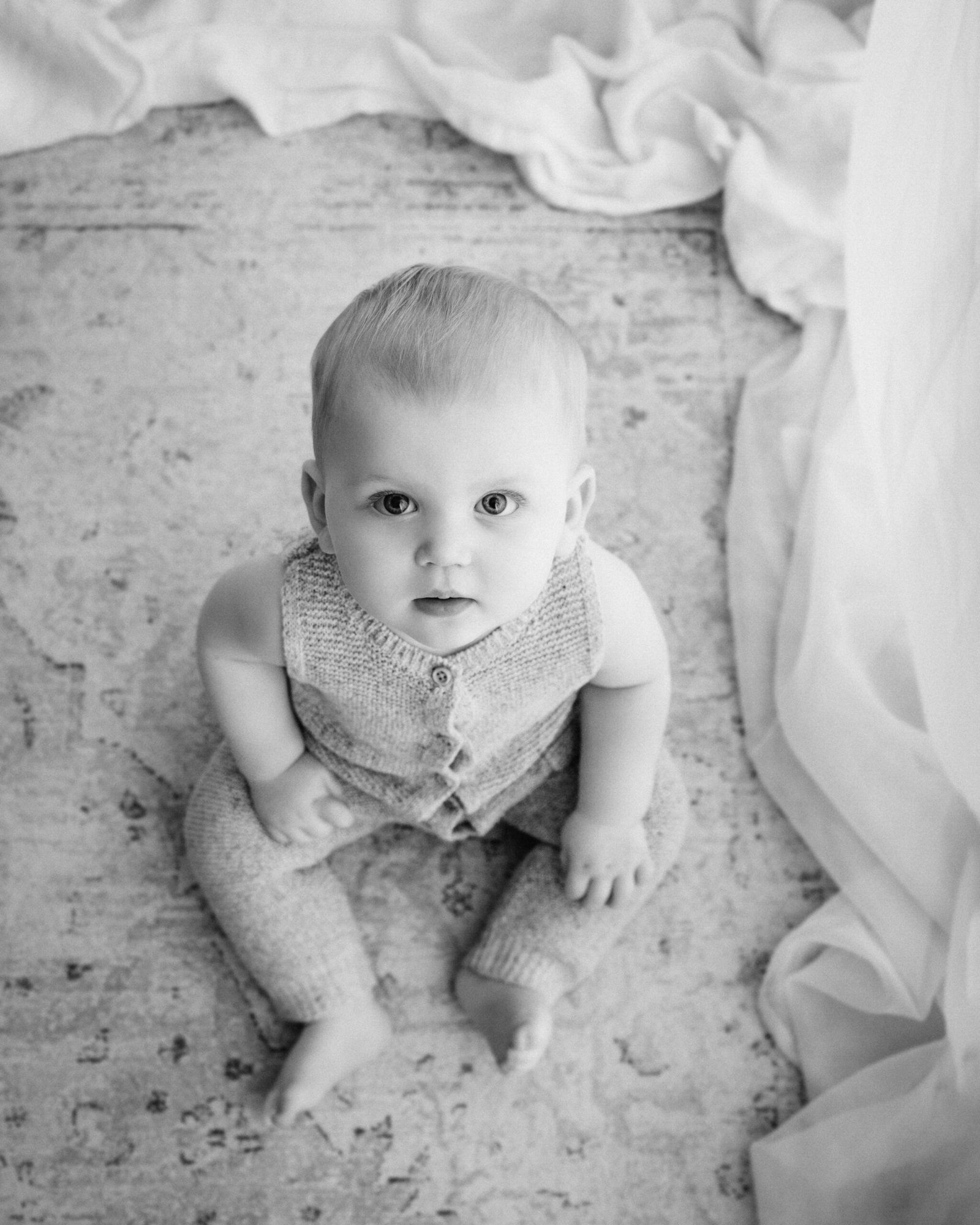 black and white image of a baby sat up during a bradford baby photographer photoshoot