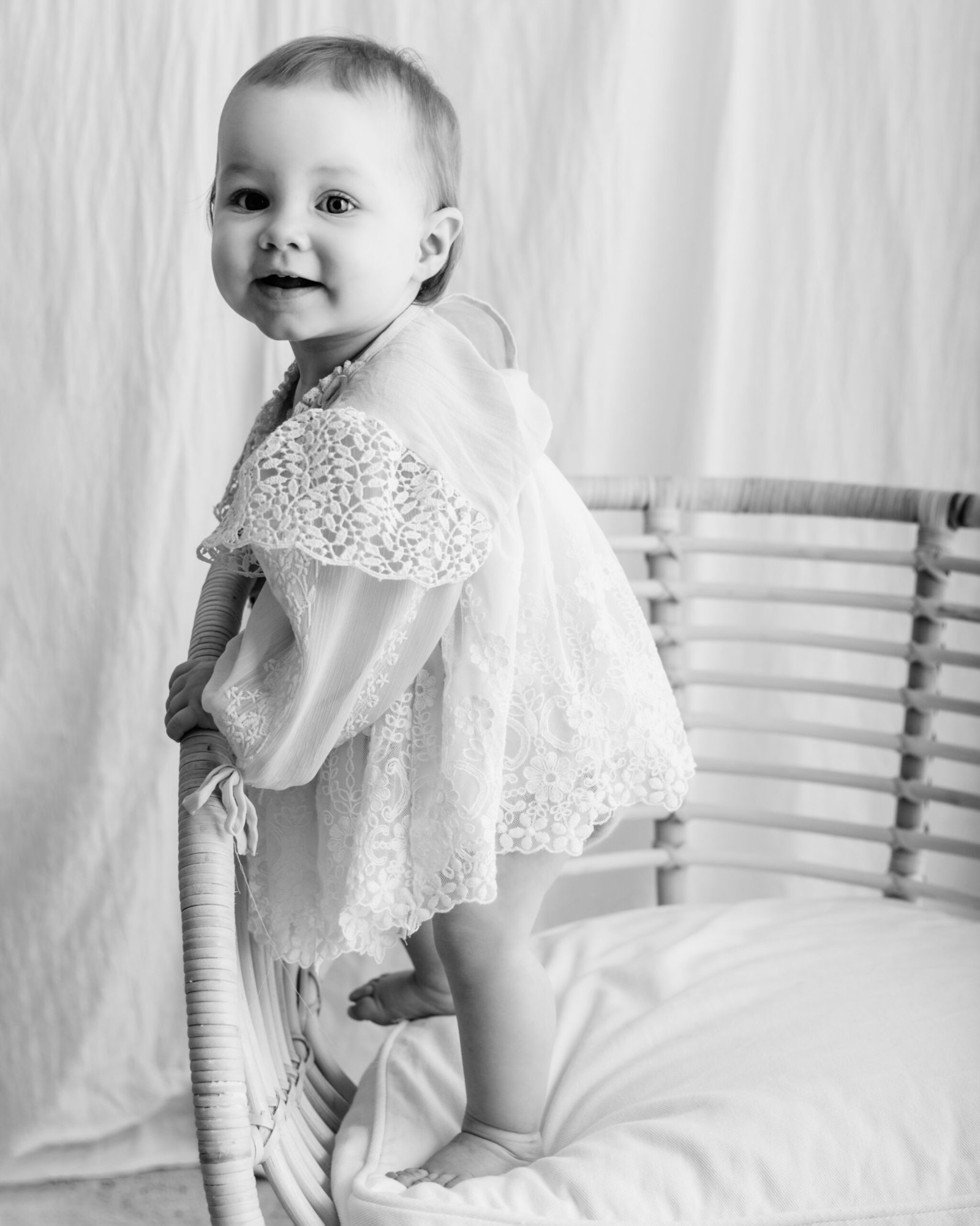 black and white image of a baby standing during a bradford baby photoshoot