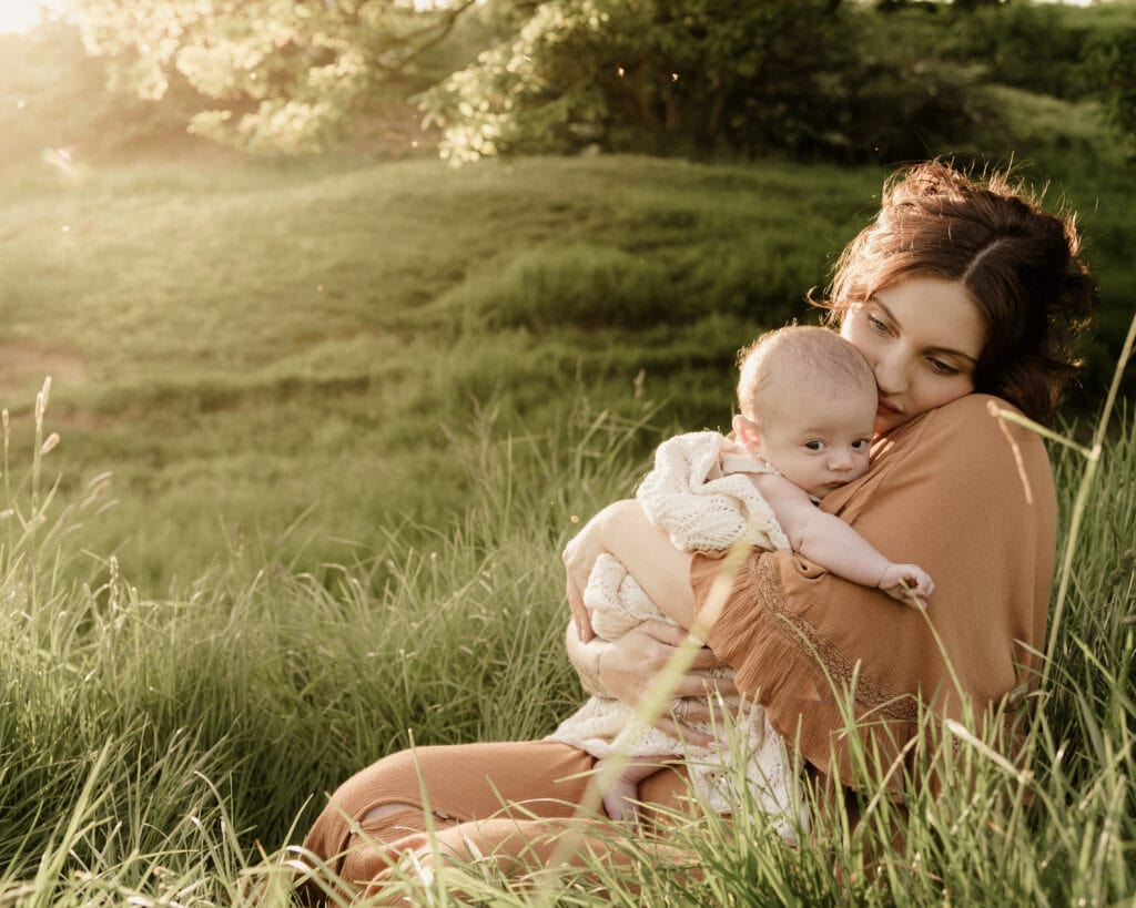 mother and baby sat in the grass at sunset during a family photoshoot in bradford